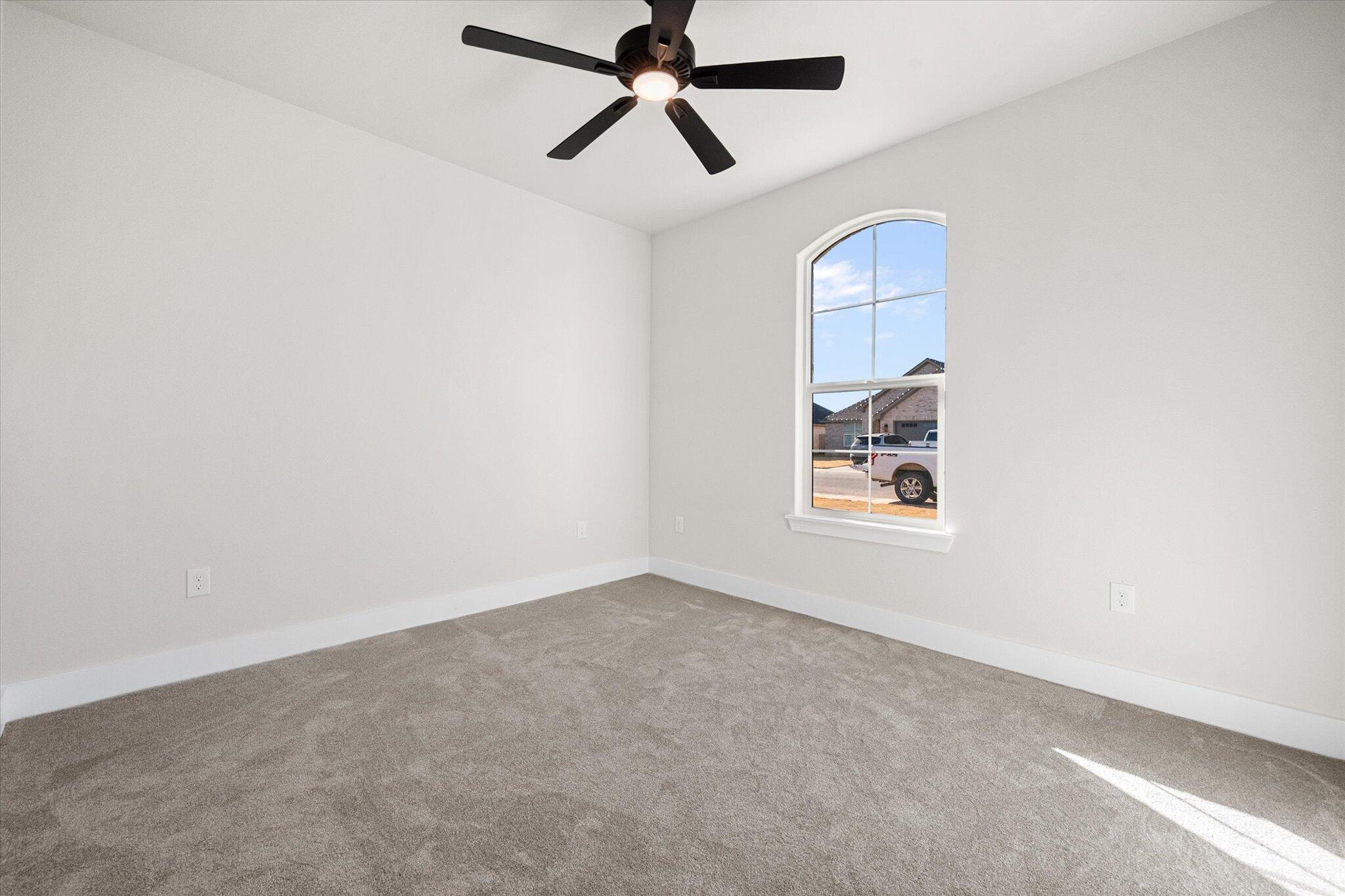 1404 Durham Avenue Wolfforth, TX 79382 - Photo 17 of 34 an empty room with windows and fan