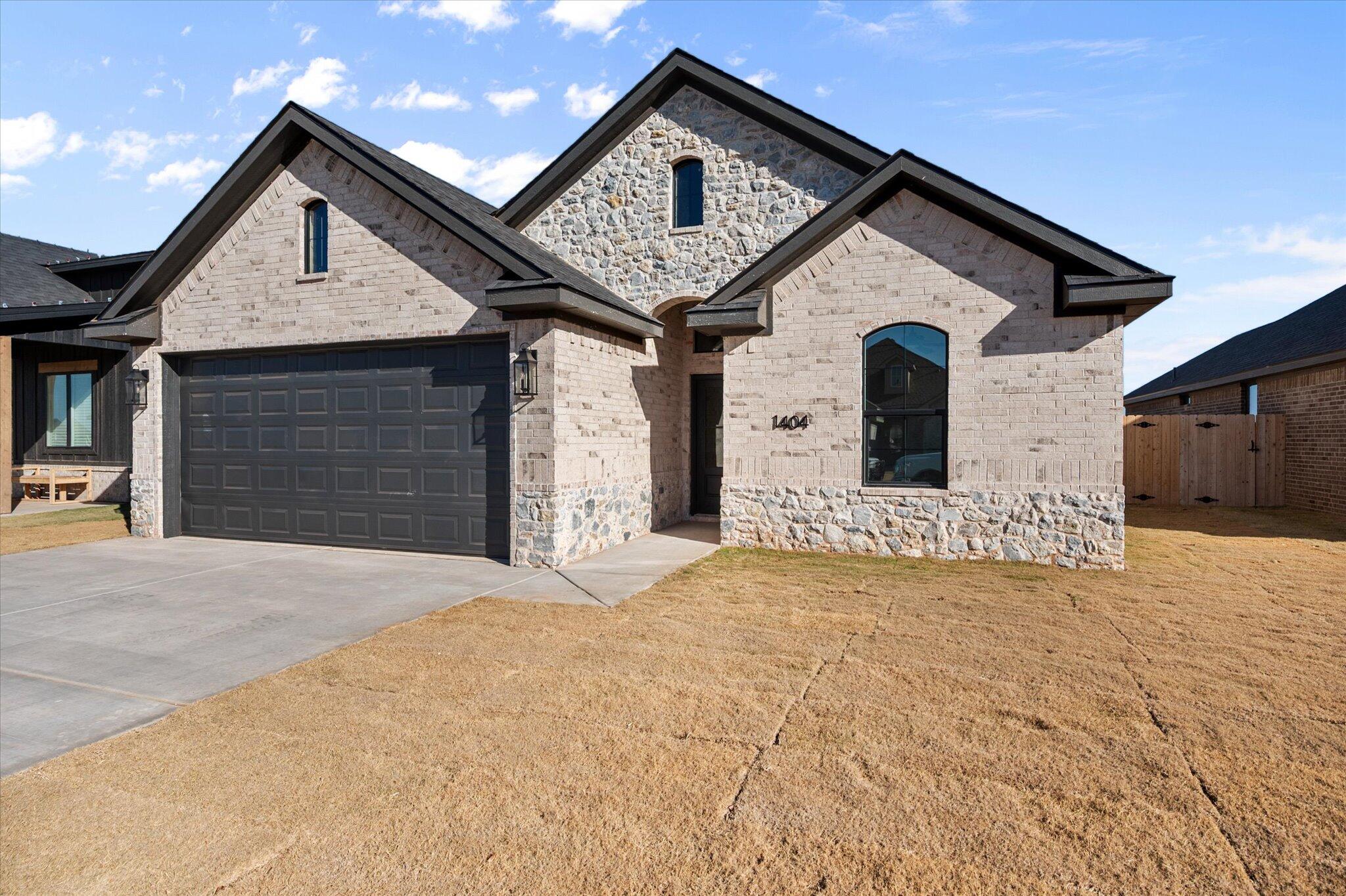 1404 Durham Avenue Wolfforth, TX 79382 - Photo 2 of 34 a front view of a house with a yard and garage