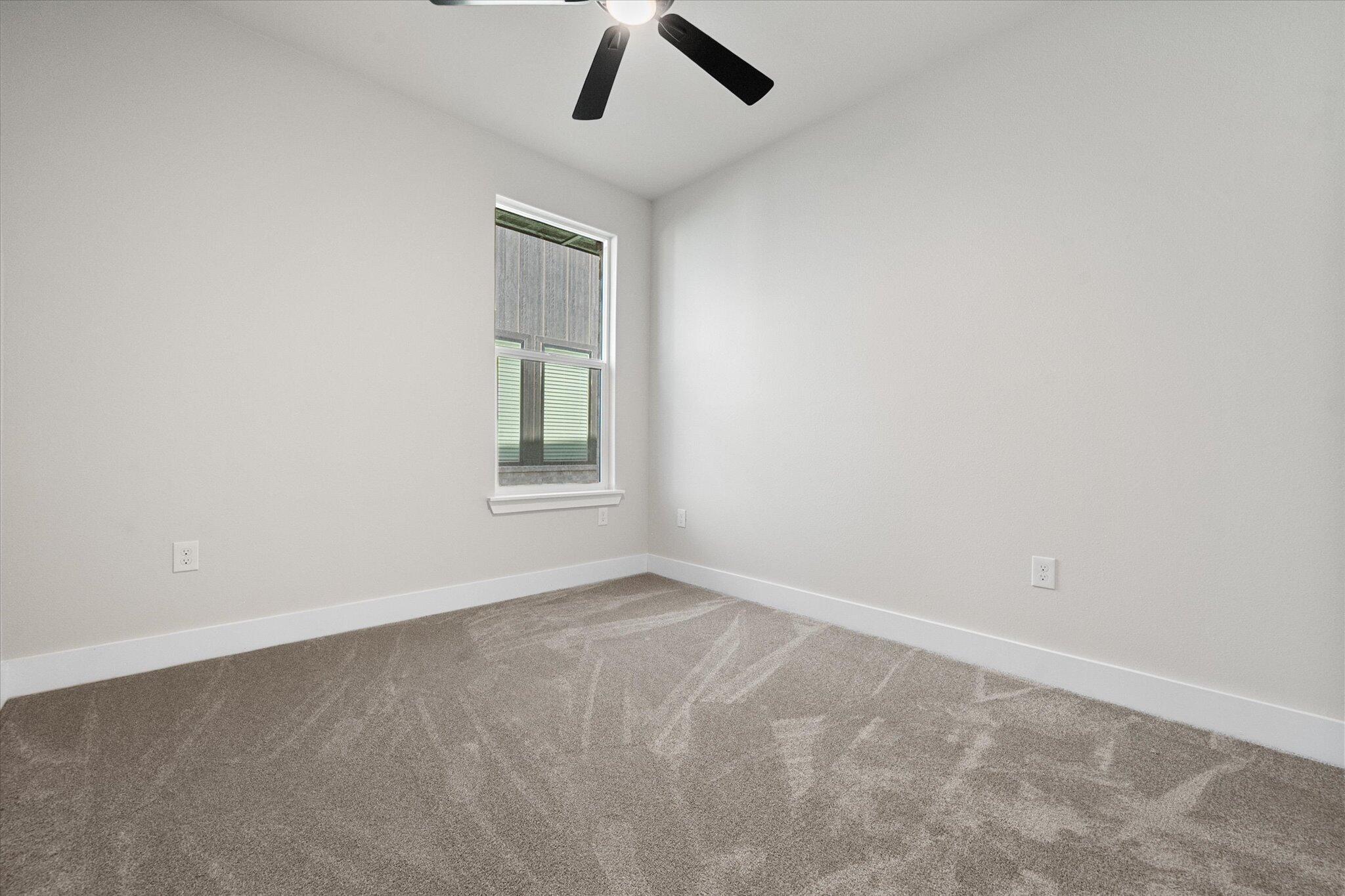 1404 Durham Avenue Wolfforth, TX 79382 - Photo 22 of 34 an empty room with a window and ceiling fan