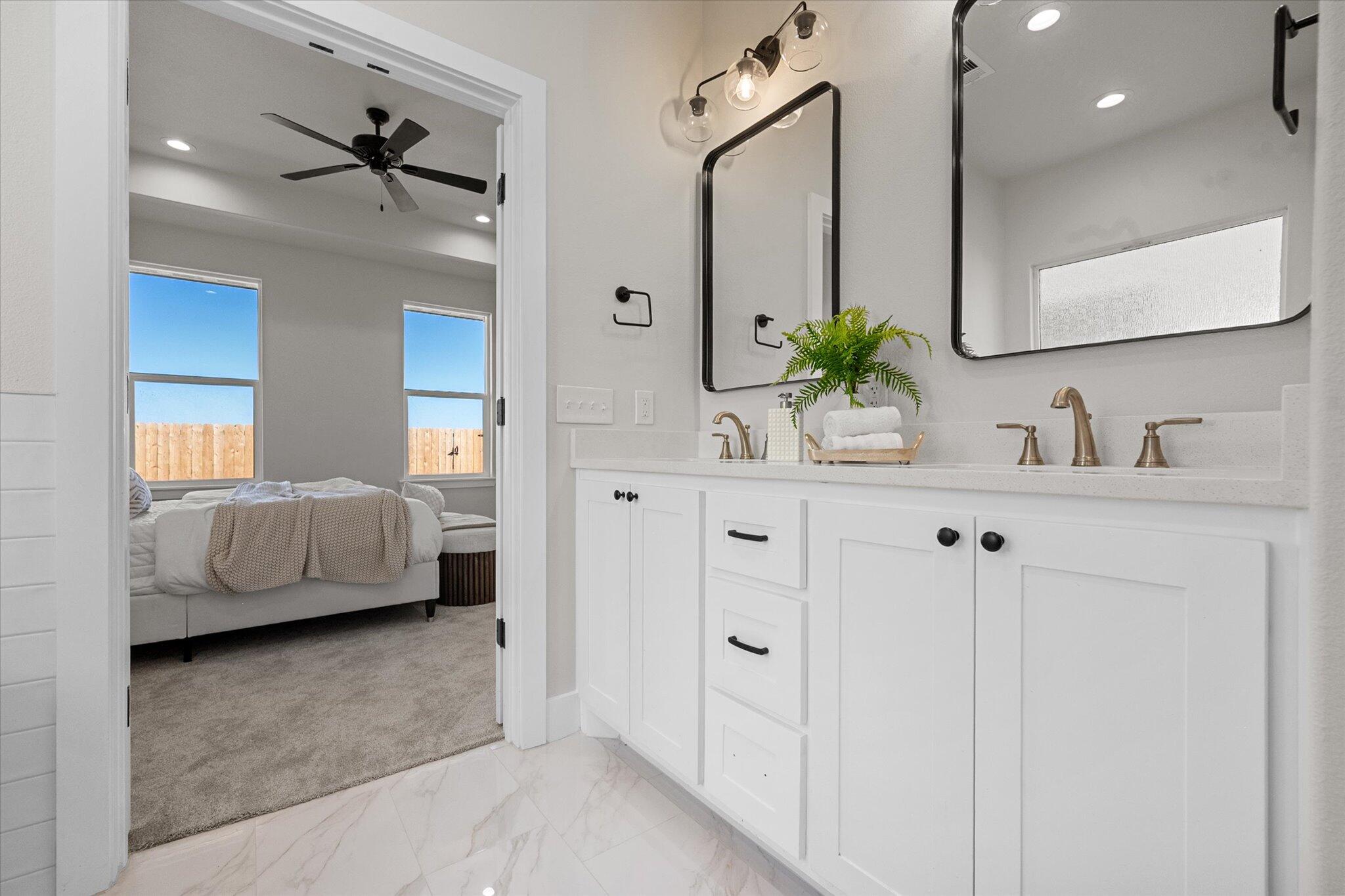 1404 Durham Avenue Wolfforth, TX 79382 - Photo 27 of 34 a en suite bathroom with a double sink and mirror