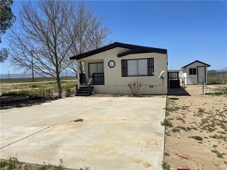 11985 Gaskell Road Rosamond, CA 93560 - Photo 3 of 12 a front view of a house with a yard covered in snow