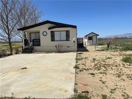 11985 Gaskell Road Rosamond, CA 93560 - Photo 8 of 12 a front view of a house with a yard covered in snow
