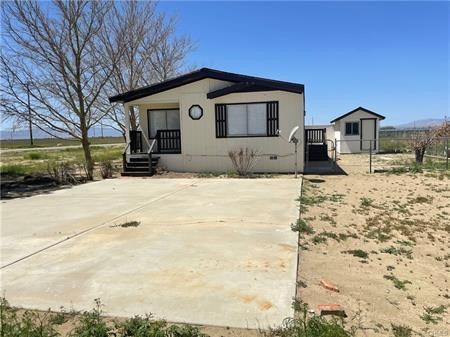 11985 Gaskell Road Rosamond, CA 93560 - Photo 9 of 12 a front view of a house with a yard covered in snow