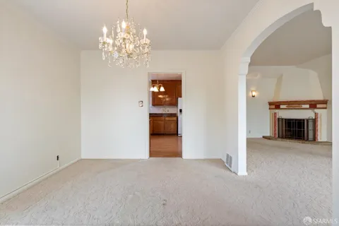 a view of a hallway with wooden floor and livingroom with furniture