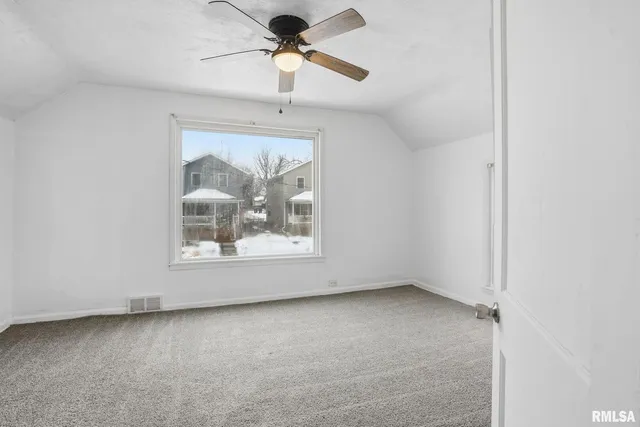an empty room with a ceiling fan and a window
