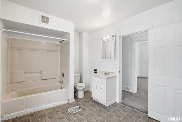 a bathroom with a granite countertop bathtub shower and toilet