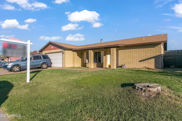 a view of a house with backyard and a tree