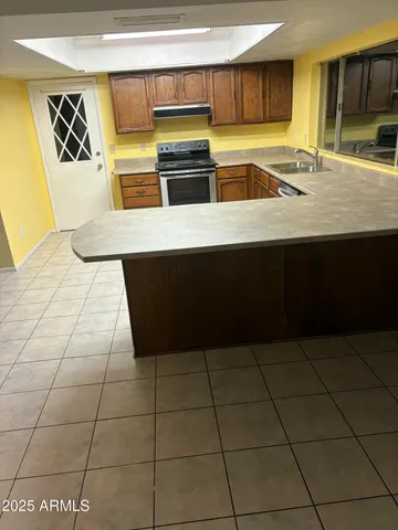 a kitchen with stainless steel appliances a sink a stove a microwave a counter top and cabinets