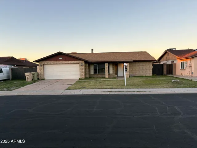 a front view of a house with a garden and yard