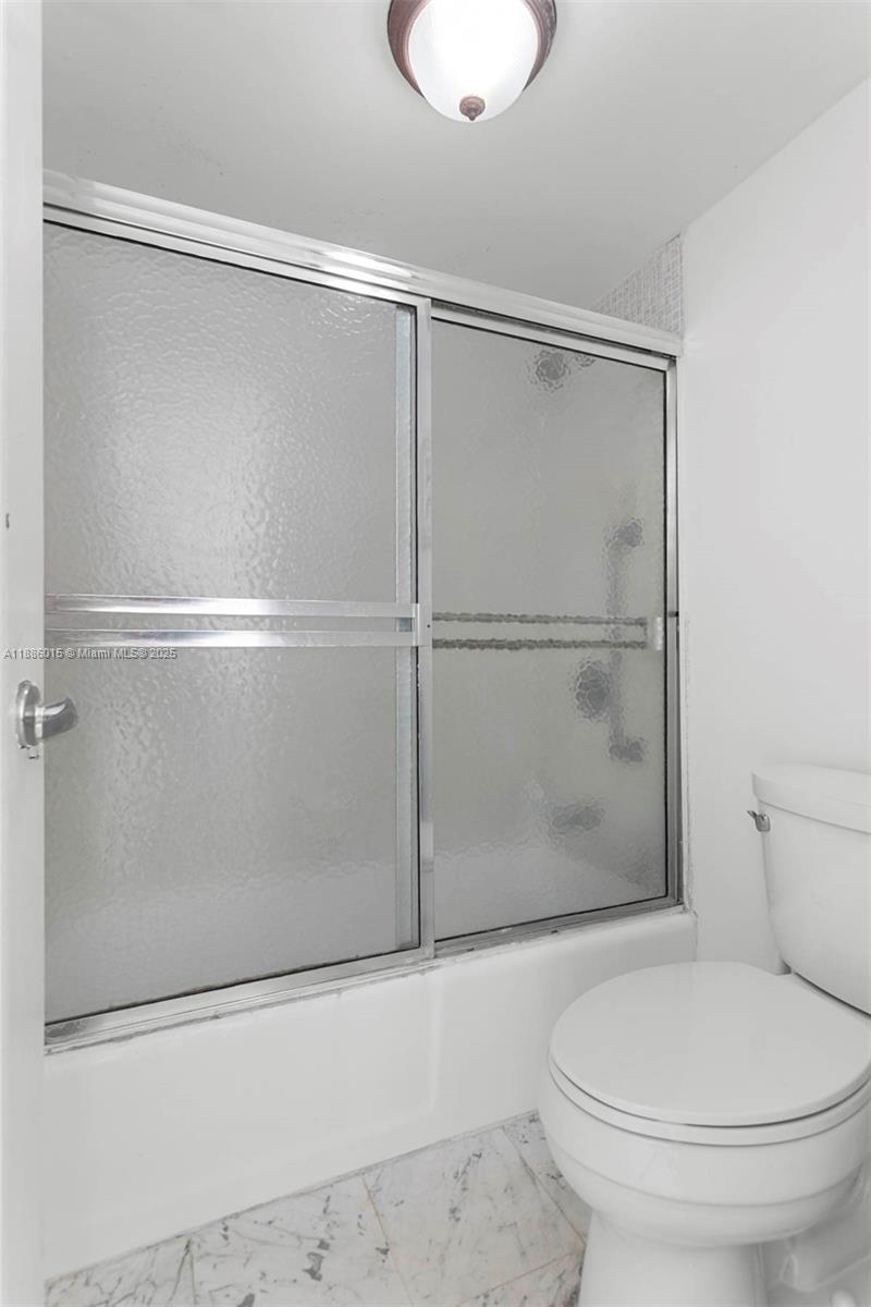 5001 Collins Avenue, Unit 5E Miami Beach, FL 33140 - Photo 12 of 17 a white toilet sitting next to a shower