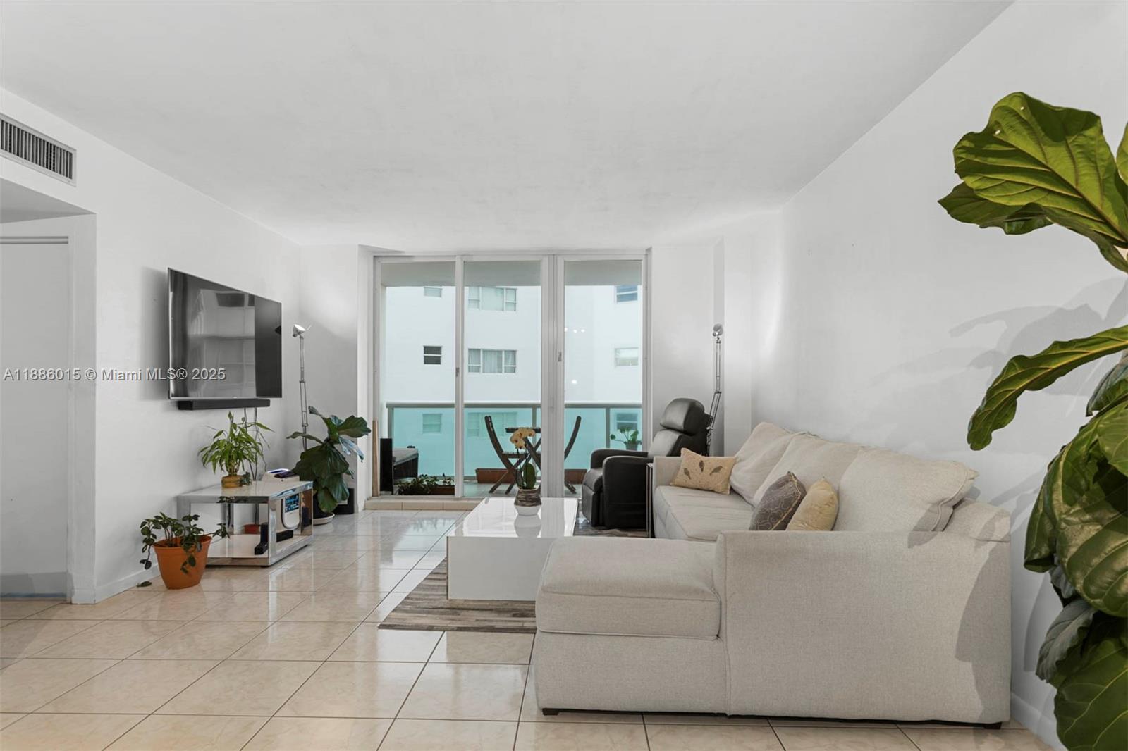5001 Collins Avenue, Unit 5E Miami Beach, FL 33140 - Photo 6 of 17 a living room with furniture and a flat screen tv