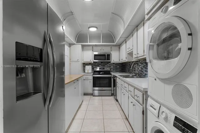 a kitchen with stainless steel appliances granite countertop a refrigerator a stove and a sink