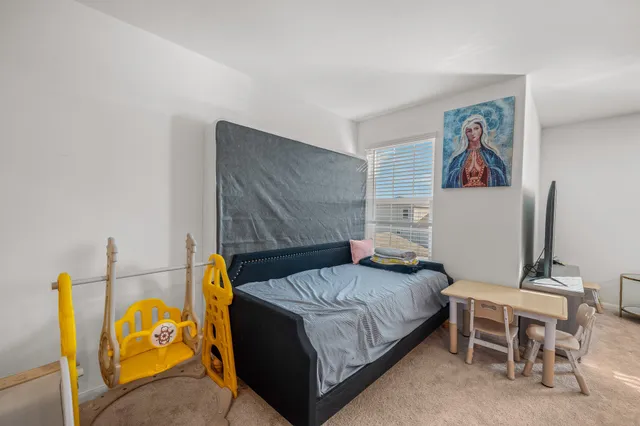 a bedroom with a bed and a wall painting