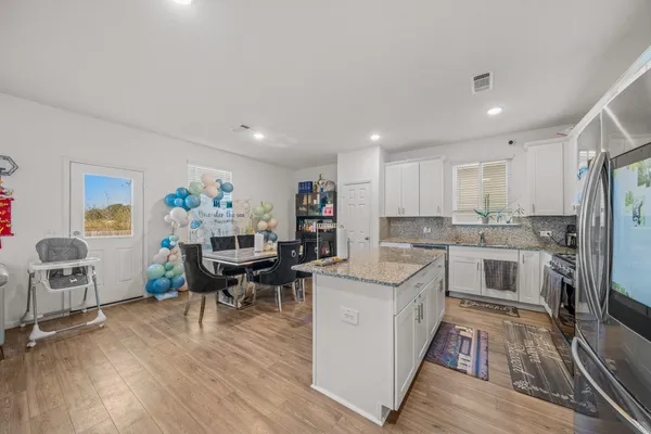 a kitchen with a sink cabinets and wooden floor