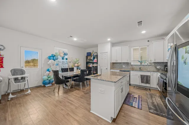 a kitchen with a sink cabinets and wooden floor