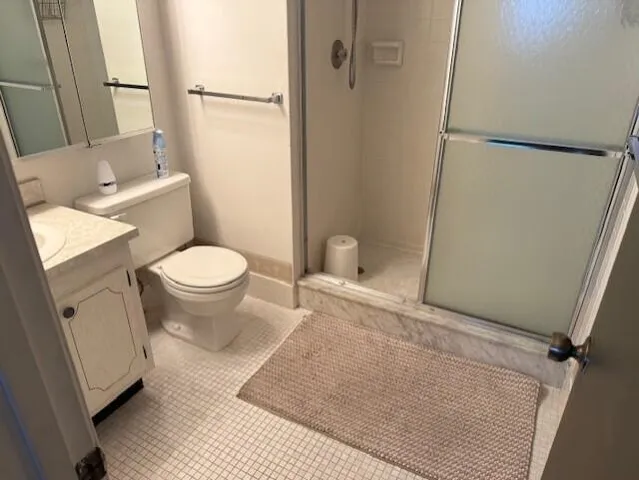a white toilet sitting next to a bathroom sink and a shower