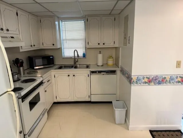 a kitchen with granite countertop white cabinets and white appliances