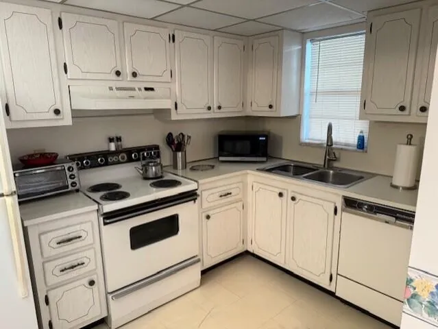 a kitchen with granite countertop white cabinets and white appliances