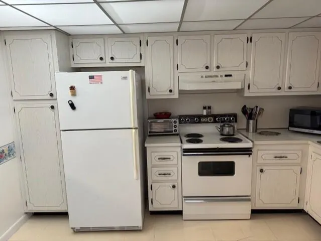 a white refrigerator freezer sitting in a kitchen