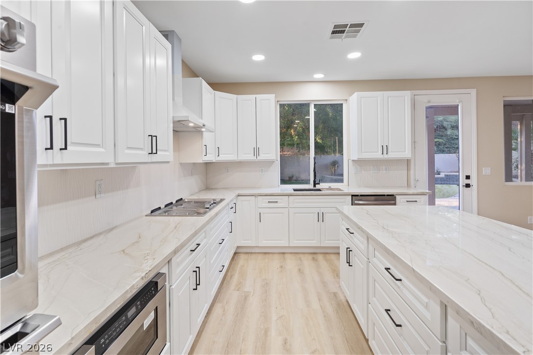 1662 Ravanusa Drive Henderson, NV 89052 - Photo 13 of 74 A luminous culinary space with abundant cabinetry and generous counter surfaces awaits inspired meal preparation.