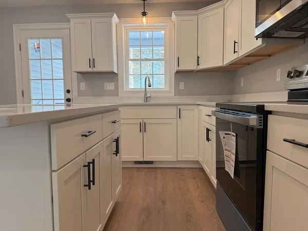 a kitchen with granite countertop white cabinets and white appliances