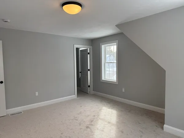 an empty room with windows and closet