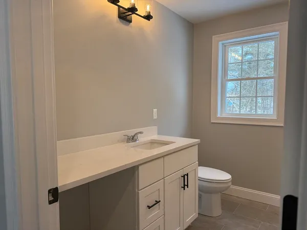 a bathroom with a sink a toilet and a window
