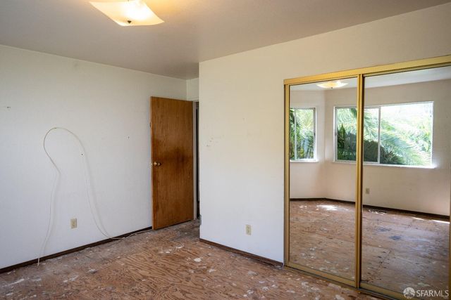 an empty room with large window and wooden floor
