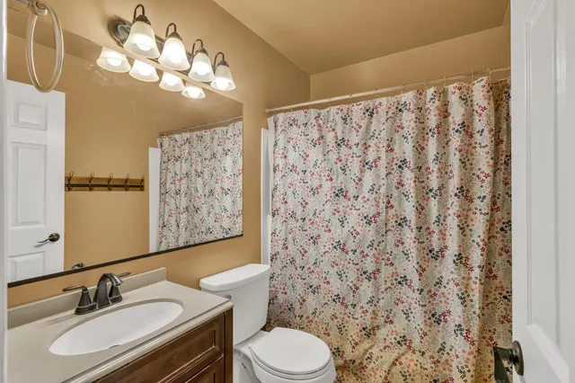 a bathroom with a sink toilet mirror and shower