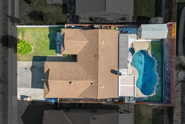 an aerial view of a residential houses with yard