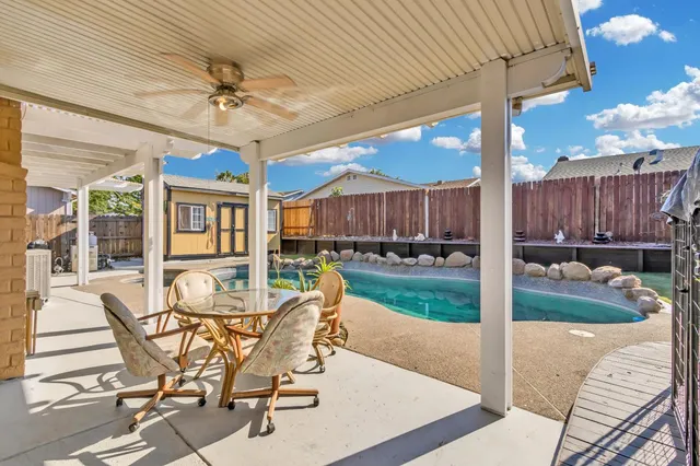 a view of a patio with a dining table and chairs with wooden floor