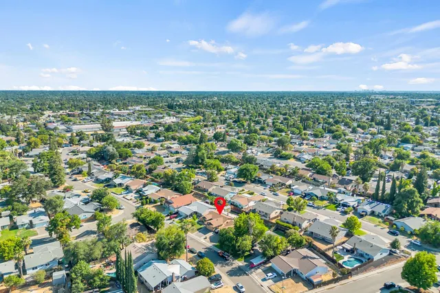 an aerial view of residential houses with outdoor space and trees