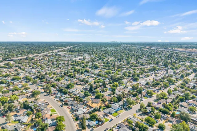 an aerial view of residential houses with outdoor space and trees