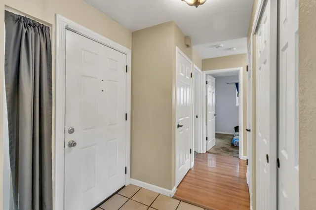 a view of a hallway with wooden floor and a bathroom