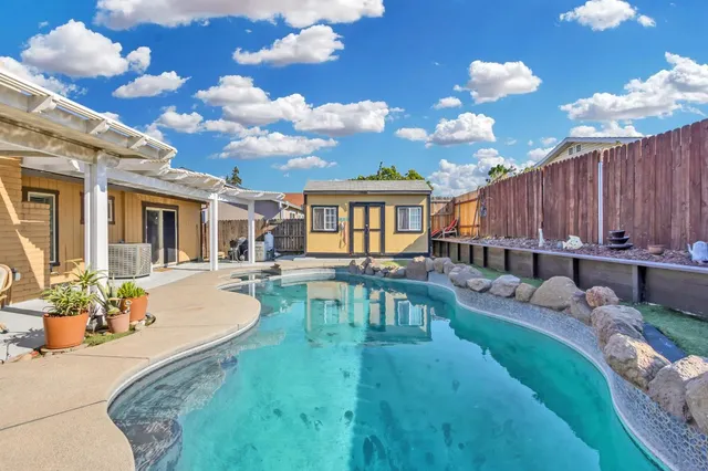 a view of a house with swimming pool and sitting area