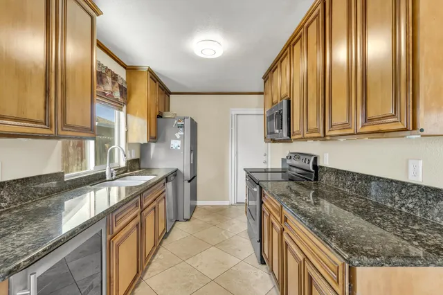 a kitchen with stainless steel appliances granite countertop a sink stove and refrigerator