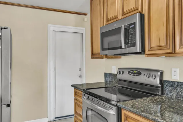 a kitchen with granite countertop a sink and a stove top oven