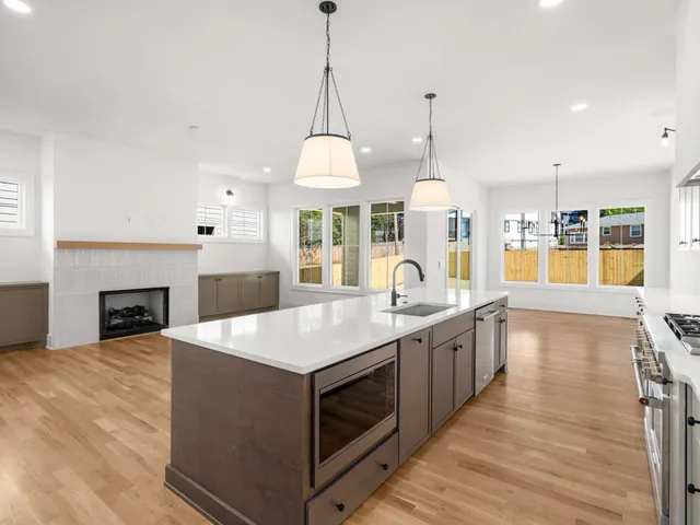 a large kitchen with granite countertop a stove oven and a wooden floors