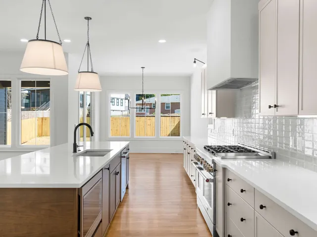 a kitchen with granite countertop a stove a sink a dining table and chairs