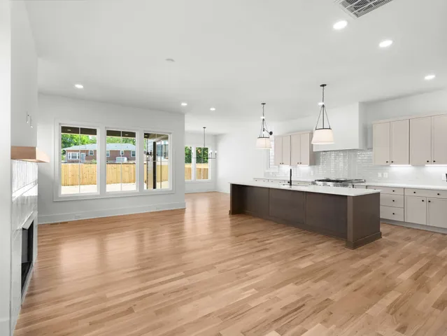 a large kitchen with large windows and wooden floor