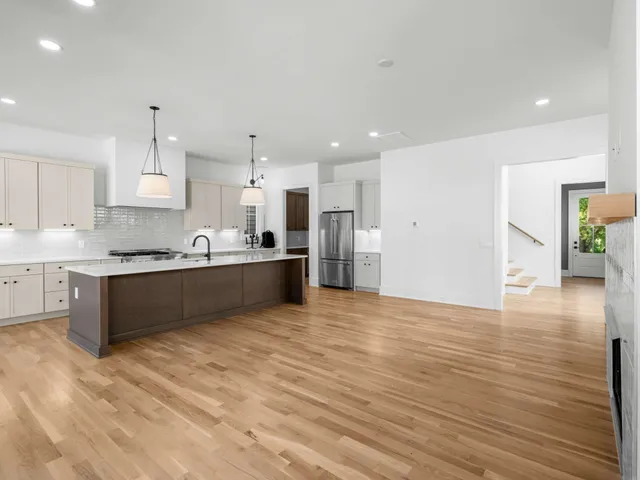 a large kitchen with kitchen island a sink stainless steel appliances and cabinets
