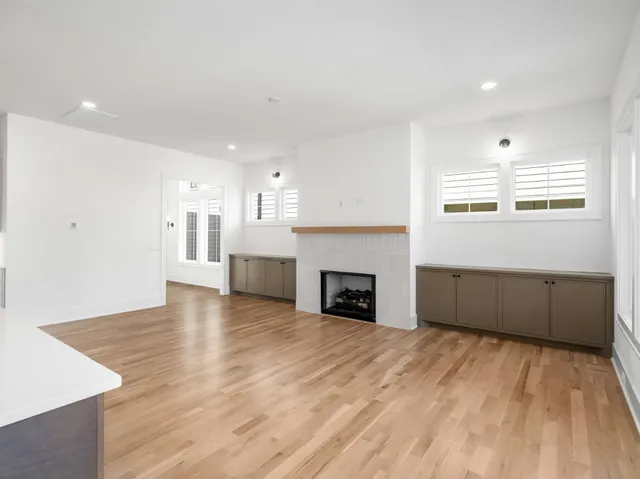 a view of empty room with wooden floor and fireplace