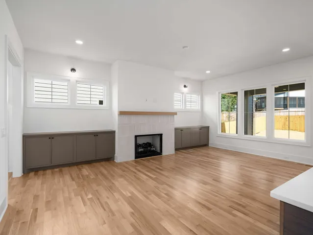 a view of an empty room with a window and fireplace