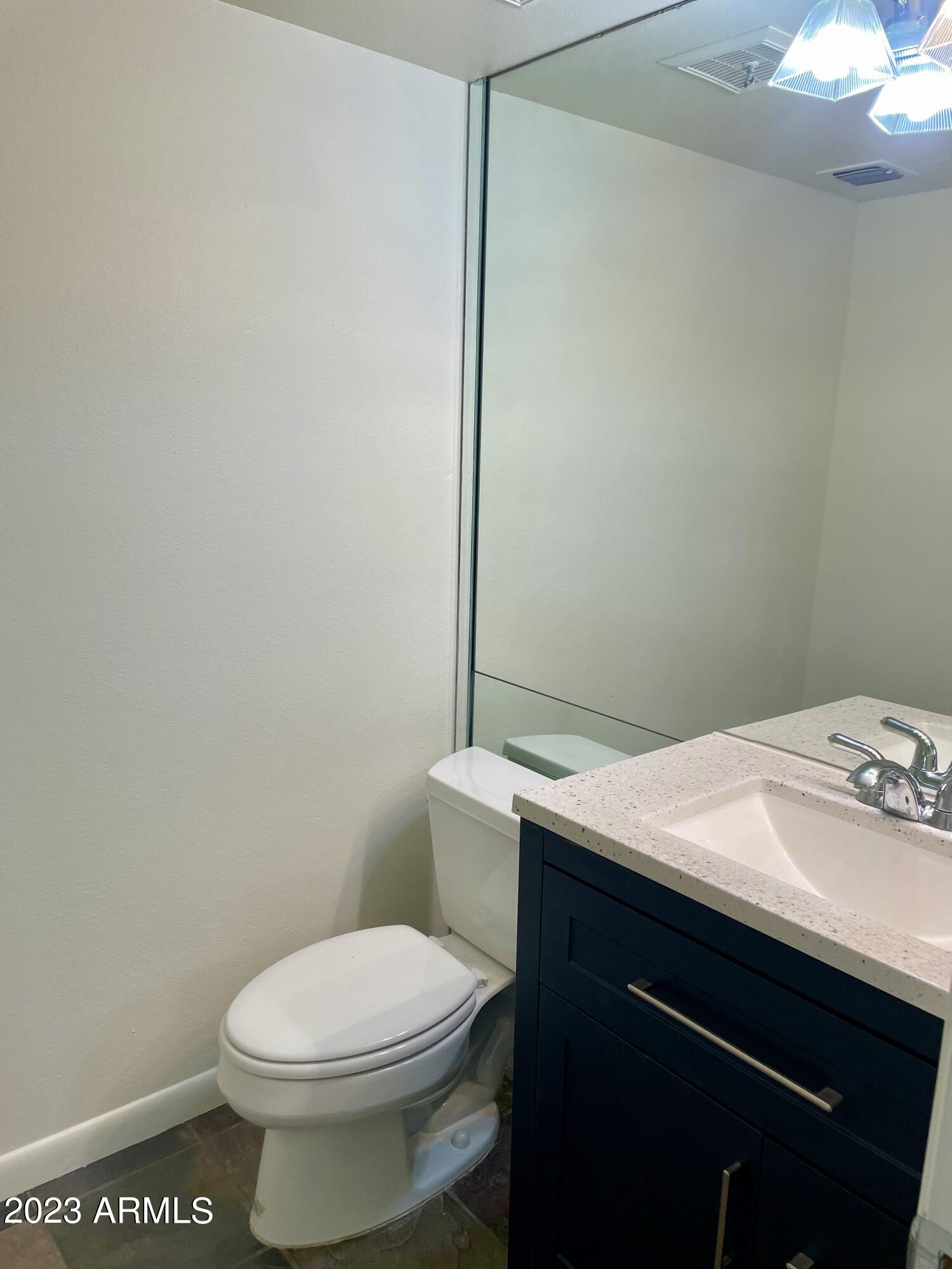 5203 North 24th Street, Unit 102 Phoenix, AZ 85016 - Photo 10 of 12 a bathroom with a granite countertop toilet and a sink