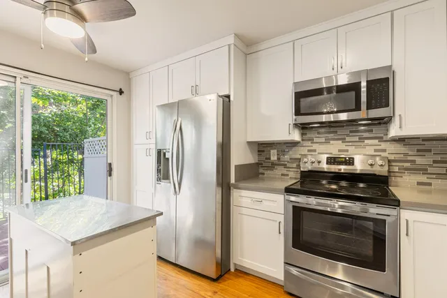 a kitchen with stainless steel appliances granite countertop a stove a refrigerator and a microwave