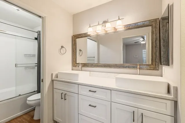 a bathroom with a sink a toilet and a large mirror