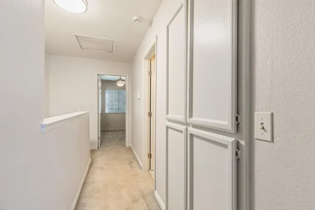 a view of a hallway with wooden floor and closet