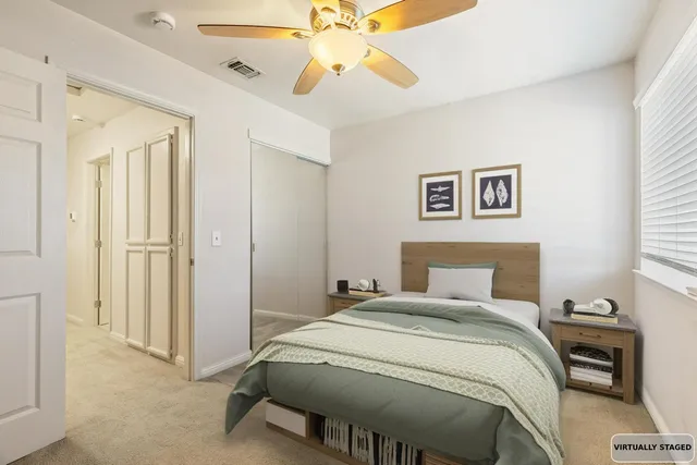 an empty room with windows and fan