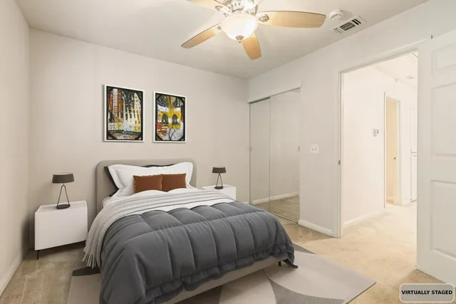an empty room with closet and a chandelier fan