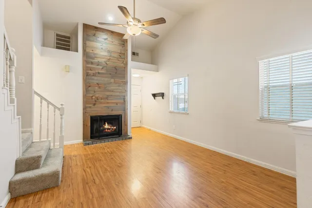 a view of empty room with fireplace and wooden floor